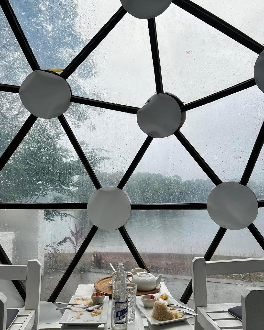Dome Mufli King — breakfast inside the dome with rain and lake visible through panels